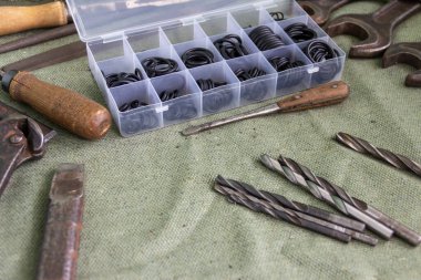 Eski çilingir aletleri muşambayla kaplı bir masada yatıyor. Tamircinin atölyesi..