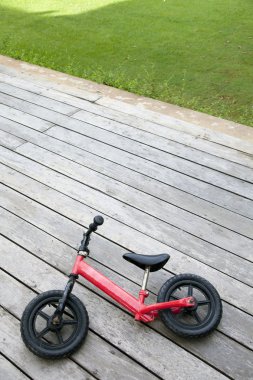 çocuk ahşap zemin üzerinde kırmızı bisiklet