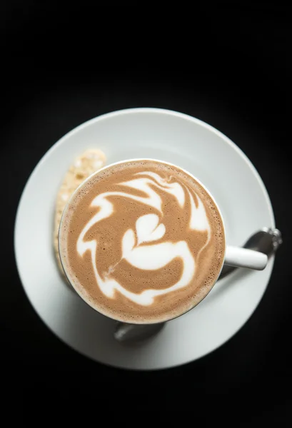 Hot mocha with latte art on black background