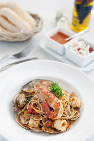 Spaghetti zeevruchten in witte plaat op tafel — Stockfoto