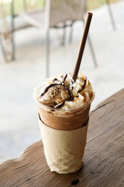 Buzlu frappe kahve, üzerinde dondurma ve ahşap masa.