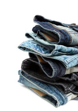 Arka planda üst üste dizilmiş kot pantolonları kapat