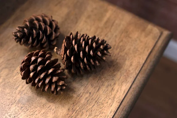 Three pieces of Pine cone on wooden table for decoration