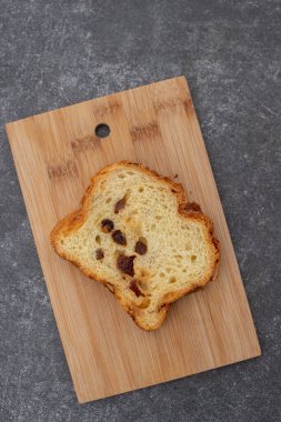 Gri beton arka plan ve ahşap tabakta kuru üzümlü ev yapımı kek. Üst görünüm, kapat, seçici odaklanma.