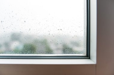 Eğimli penceresinde (cam yağmur damlaları)