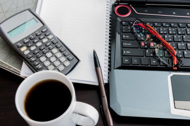 kahve fincanı, laptop, belge dosyası, kalem, hesap makinesi, not defteri bir
