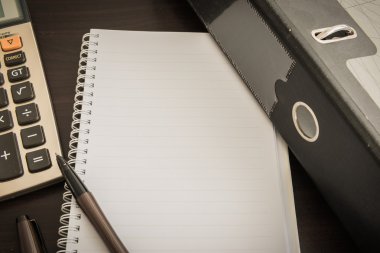 belge dosyası, kalem, hesap makinesi, ahşap masa üstünde not etmek