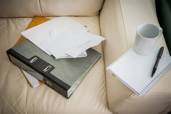 Kaffekopp, penna, notebook, dokumentfil är vita soffan — Stockfoto