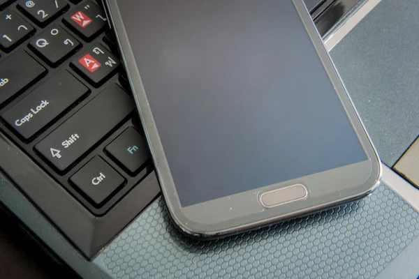 Smartphone on laptop keyboard — Stock Photo, Image