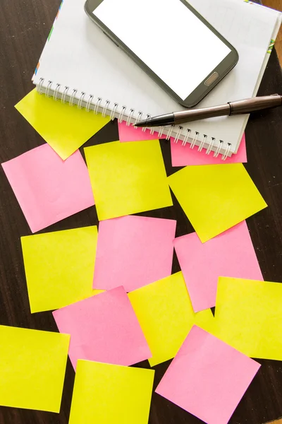 smartphone , notepad with pen and reminder notes on the table