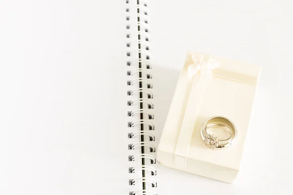 Anillo de compromiso y caja de regalo en el cuaderno — Foto de Stock