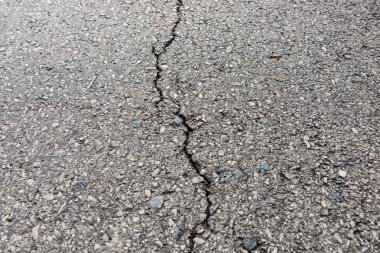 Old worn and cracked asphalt with cracks clipart