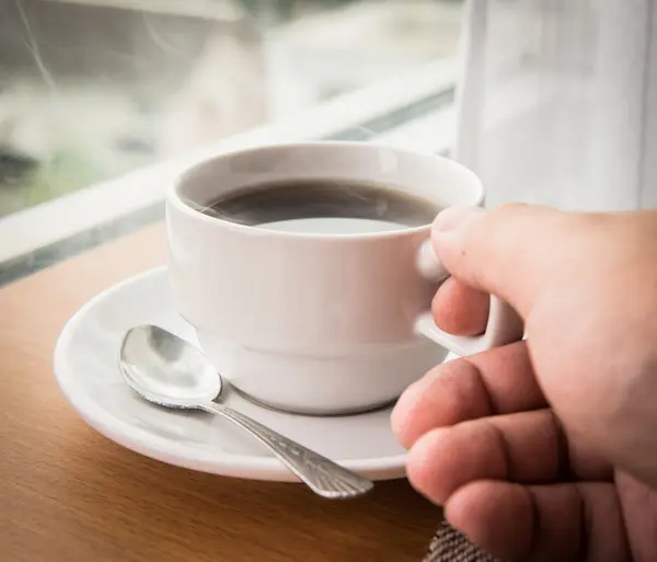 Segurando xícara quente de café — Fotografia de Stock