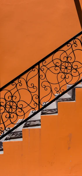 Turuncu duvar ve siyah merdiven — Stok fotoğraf