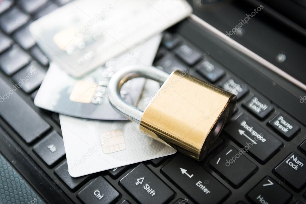 Padlock and credit cards on top of laptop