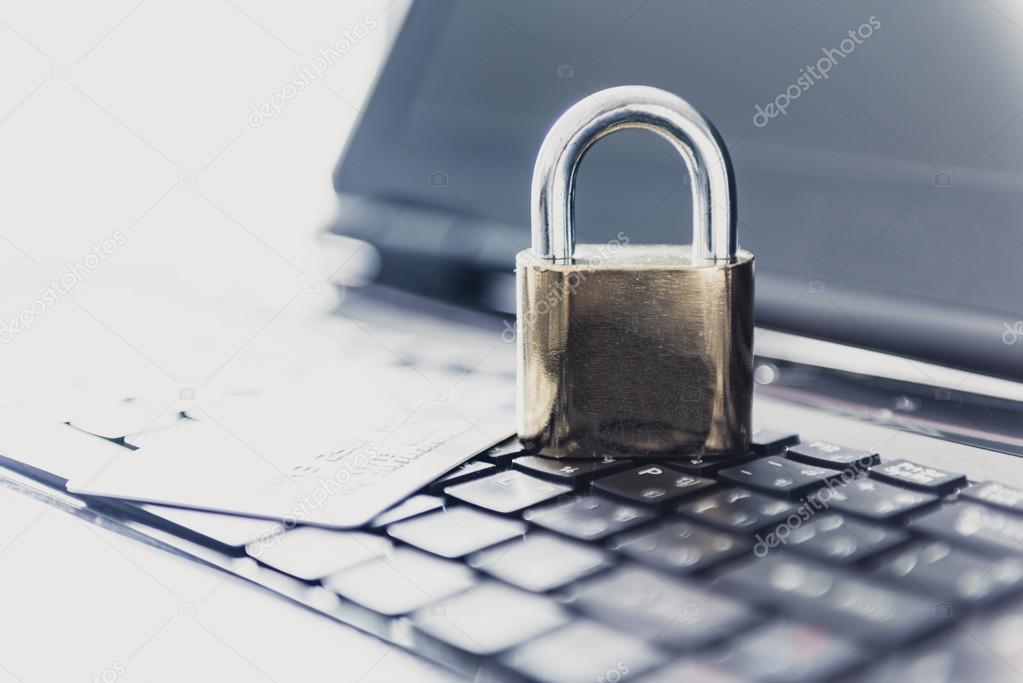 Padlock and credit cards on top of laptop