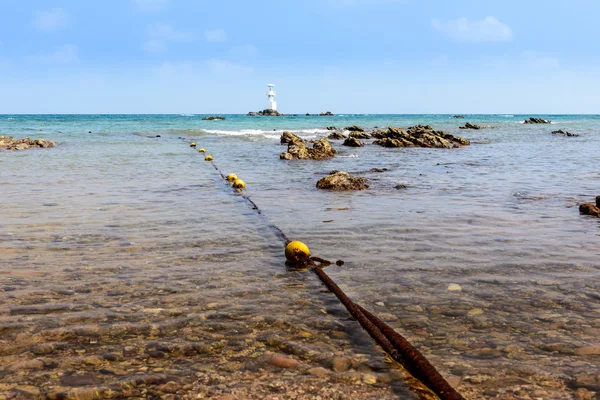 Bóias e farol na pedra e no mar — Fotografia de Stock