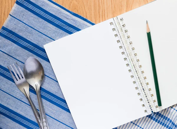 Notebook , silver spoon and fork — Stock Photo, Image