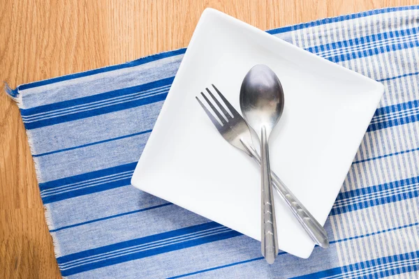 Piatto bianco e cucchiaio e forchetta d'argento — Foto Stock
