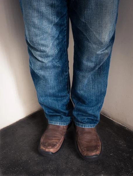 Zbliżenie nogi młody człowiek stojący w rogu — Zdjęcie stockowe