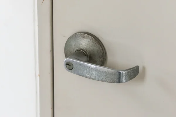 Detail kovového knoflíku na šedé dveře — Stock fotografie