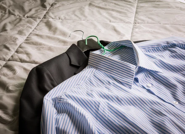 Ανδρικά πουκάμισα κλασικά και κοστούμι στο κρεβάτι — Φωτογραφία Αρχείου
