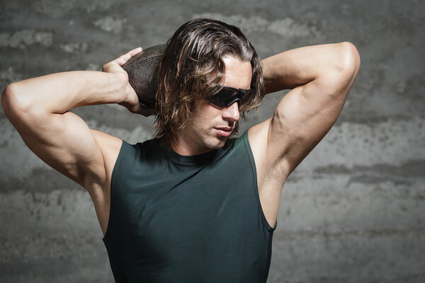 Long hair athlete wearing green tank top and sunglasses