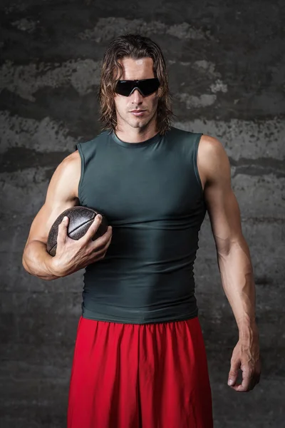 Muscle man holding football ball — Stock Photo, Image