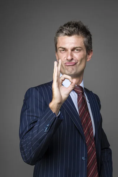 Elegante homem de negócios satisfeito em gesto ok — Fotografia de Stock