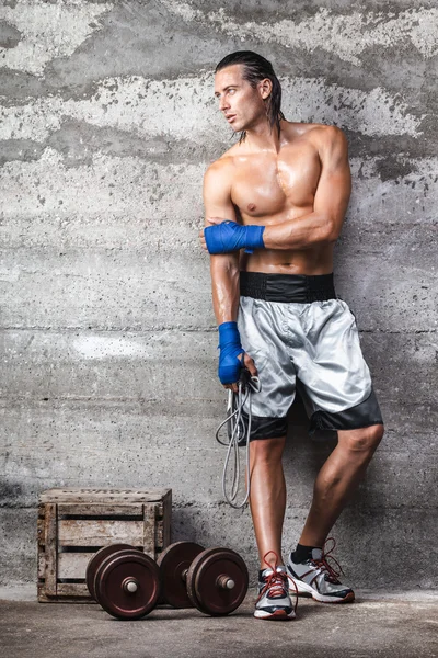 Attractive boxer man standing on the wall and looking aside — Stock Photo, Image