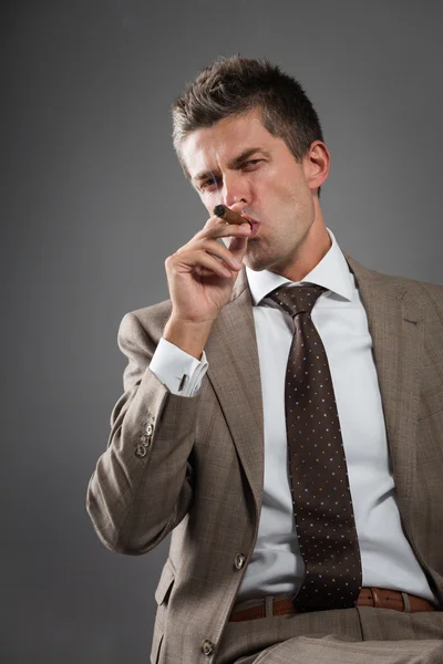 Businessman smoking a cigar — Stock Photo, Image