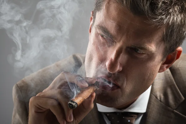 Hard gaze businessman while smoking a cuban cigar — Stock Photo, Image