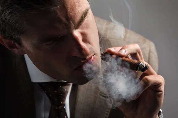 Elegant businessman smoking a cuba cigar — Stock Photo, Image
