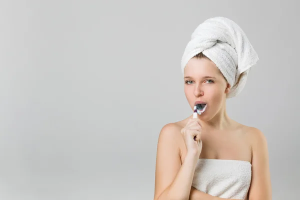 Молодая девушка чистит зубы с открытым ртом — стоковое фото