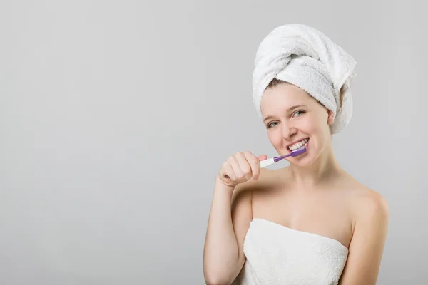 Beautiful young girl brushing her teeth — Stock Photo, Image