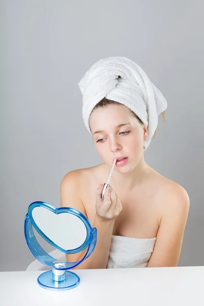 Beautiful teenager applying lipstick in the mirror — Stock Photo, Image