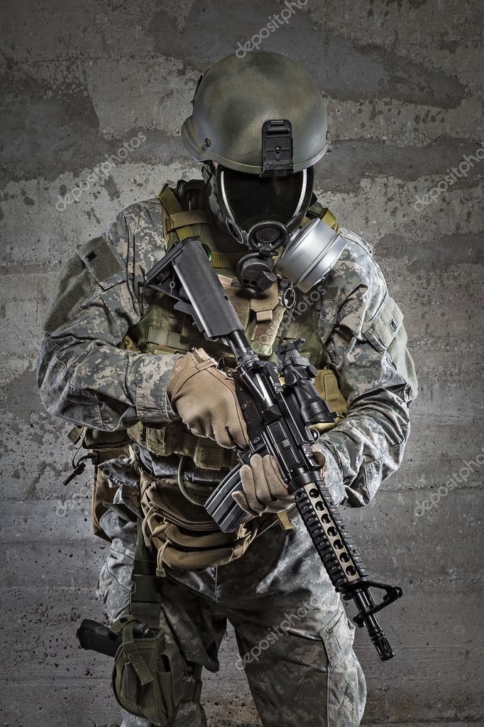 Hombre soldado de pie contra un campo. soldado en traje militar con chaleco  antibalas. foto de un soldado en traje militar sosteniendo una pistola y  chaleco antibalas sobre fondo naranja del desierto.