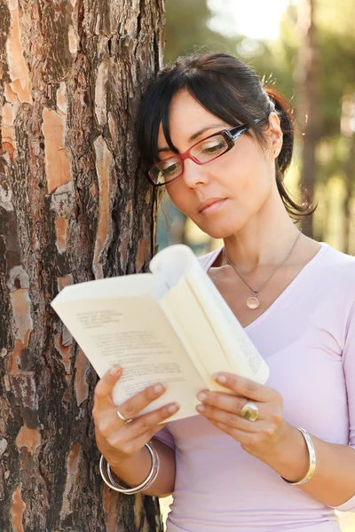 Жінка читає книгу надворі — стокове фото