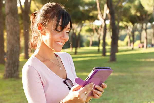 Glimlach vrouw haar buiten ebook lezen — Stockfoto
