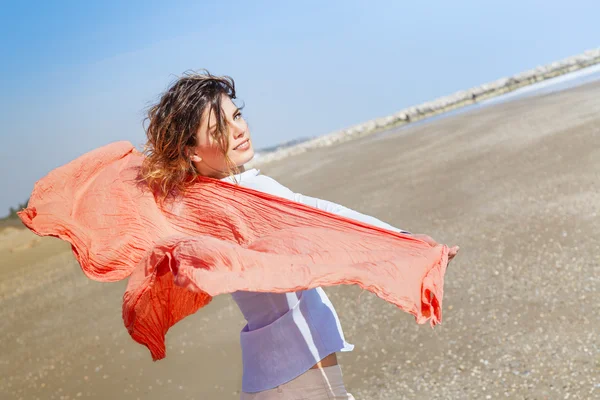 Menina bonita com cachecol vermelho na praia — Fotografia de Stock