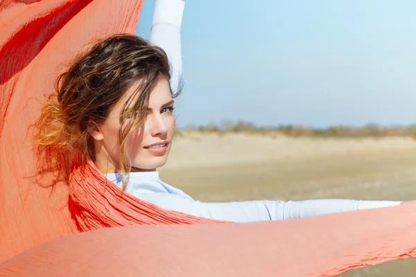 Porträtt av en attraktiv tjej med röd scarf på vinden — Stockfoto