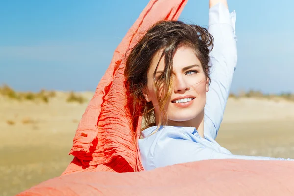 Porträtt av en vacker flicka med röd halsduk på stranden — Stockfoto