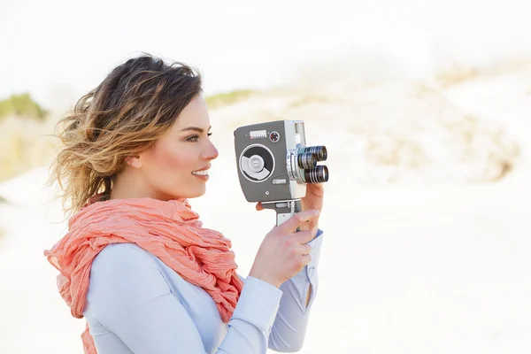 Retrato al aire libre de mujer joven sosteniendo la cámara vintage de 8mm — Foto de Stock