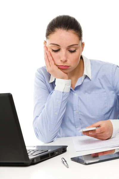 Young bored businesswoman using phone on her desk — Stock Photo, Image