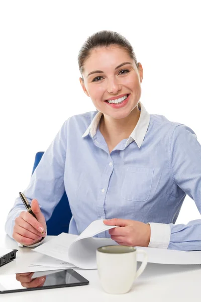 Jonge Glimlachende zakenvrouw camera kijken op haar Bureau Stockfoto
