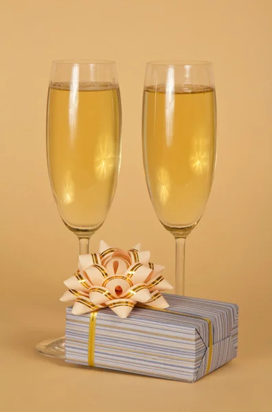 Copos de vinho com champanhe e uma bela caixa de presente — Fotografia de Stock