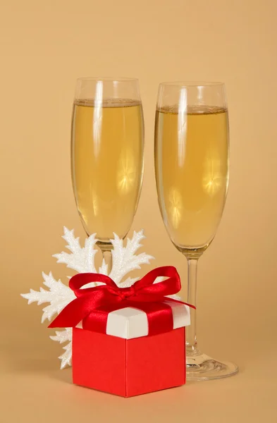 Wine glasses, a red gift box and a snowflake — Stock Photo, Image