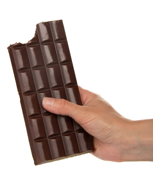 Vrouwelijke hand met een tegel van zwarte chocolade waar het segment is gebeten gebroken, geïsoleerde op wit — Stockfoto