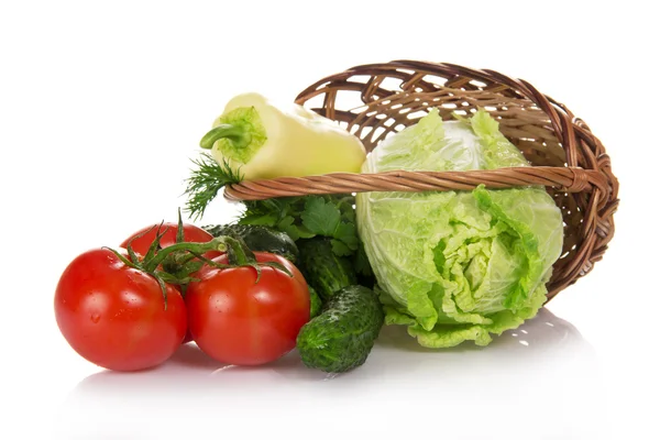 Le chou, les concombres, les tomates et les légumes verts, sortis d'un panier, isolés sur du blanc — Photo