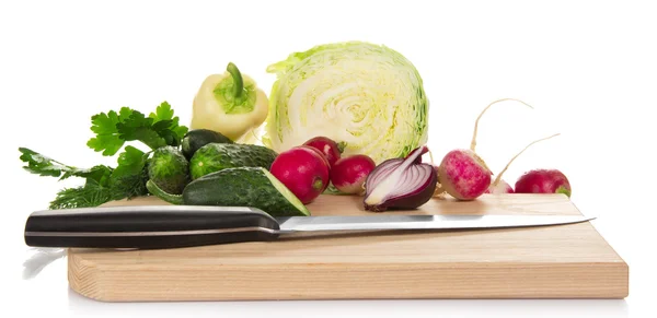 Kool, komkommers, peper, radijs, uien en greens, mes op de snijplank, geïsoleerd op wit — Stockfoto